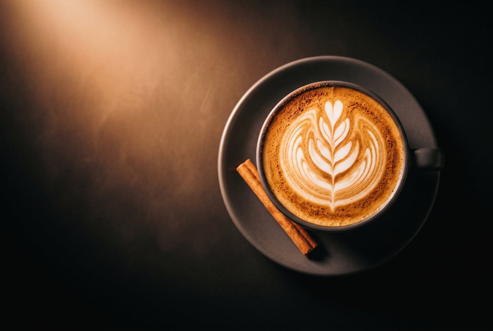 Cappuccino con roseta de latte art en taza de cerámica.